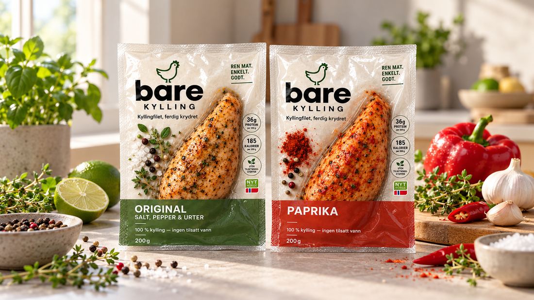 De to pakkene Bare Kylling, Original og Sweet Paprika, på en solfylt kjøkkenbenk med rød paprika, hvitløk, pepperkorn og urter.